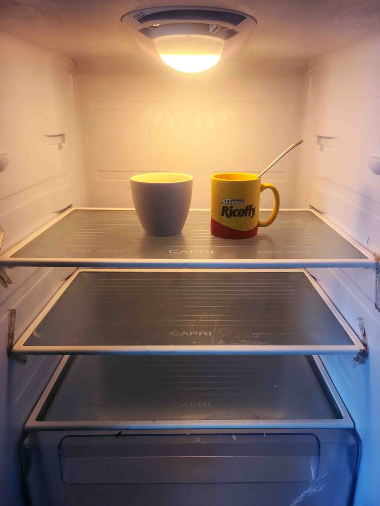 Empty Fridge with 2 cups of coffee