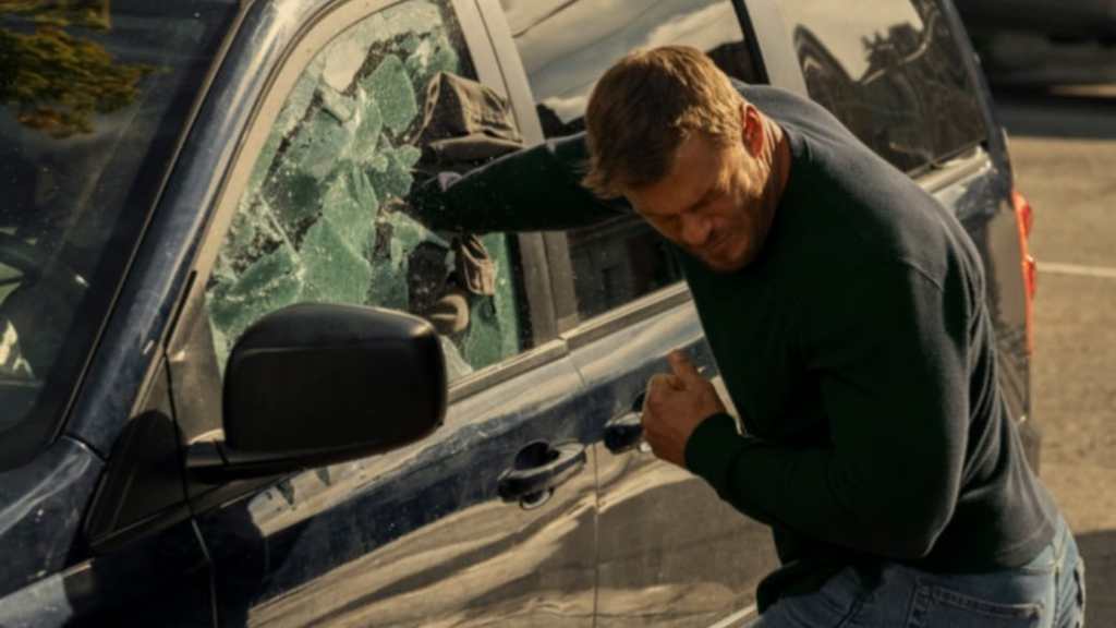 Reacher breaks a car window

